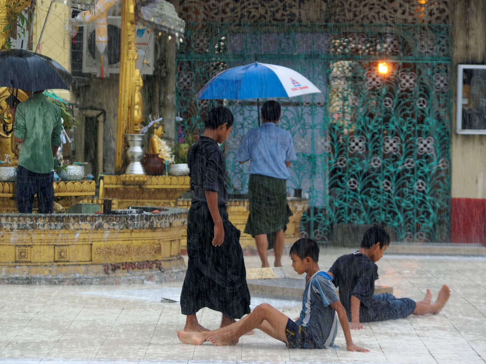 人们在雨中经过传统建筑，红桃视频移动访问说明配图